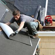 Roofing technician lays new sheeting